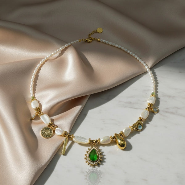 elephantina.gr gold necklace with pearls, green oval stone, coin, evil eye, and drop charms