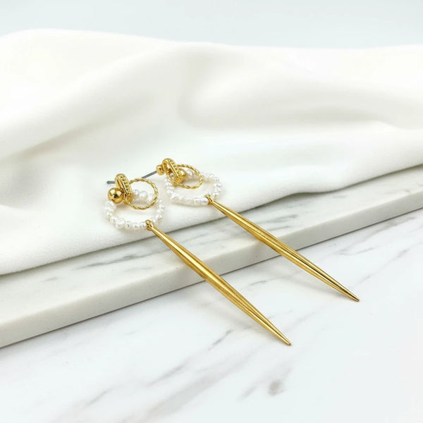 elephantina.gr long gold drop earrings with pearl-encrusted hoops and pointed gold dangles.