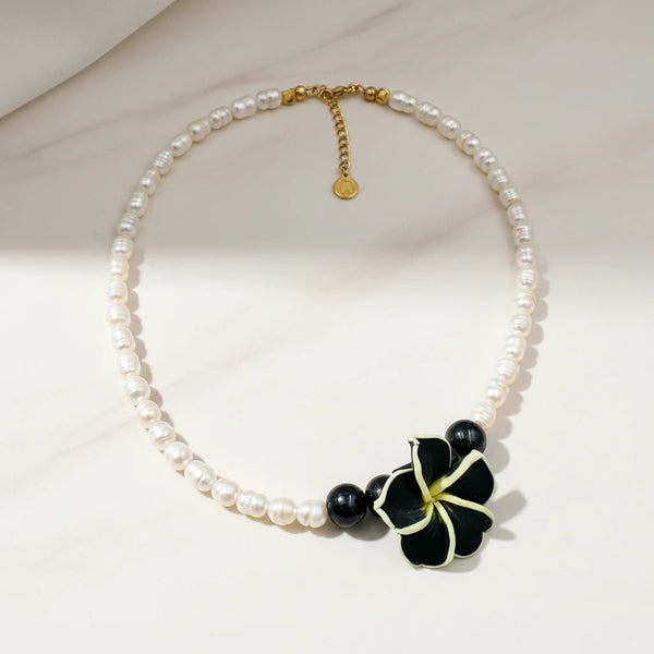 elephantina.gr handmade necklace with white pearls, black beads, and a black and yellow flower pendant.