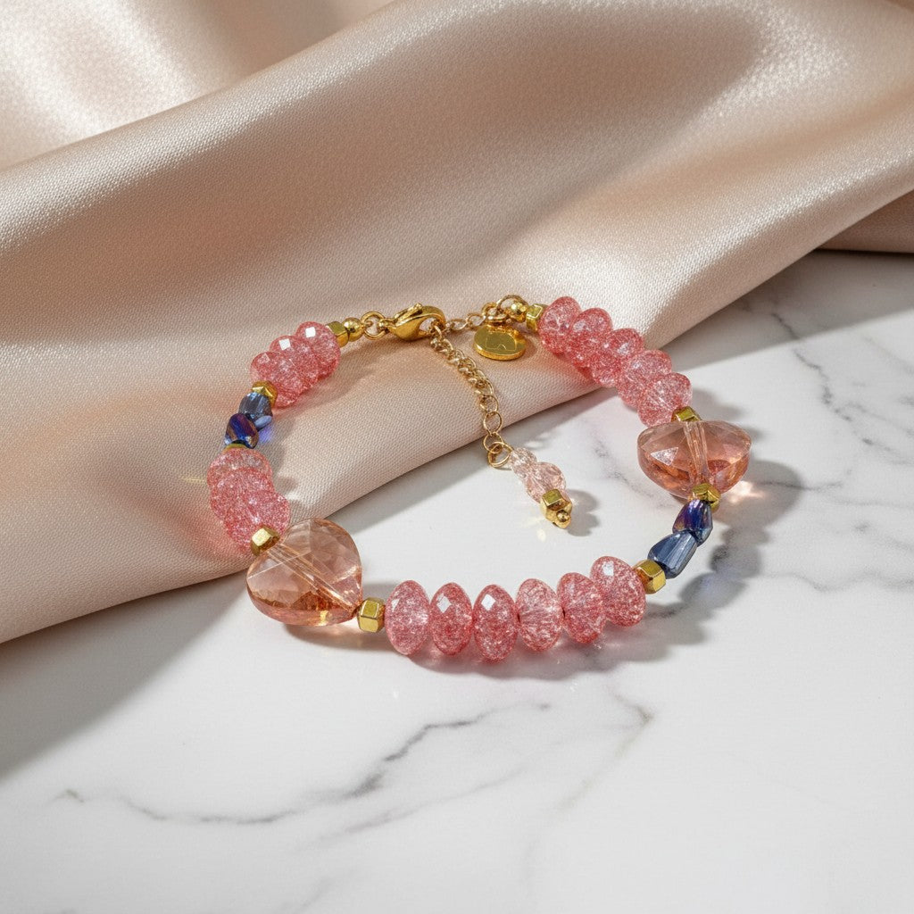 Elephantina.gr handmade bracelet with pink crystal rondelles, peach heart charms, and dark blue iridescent beads.