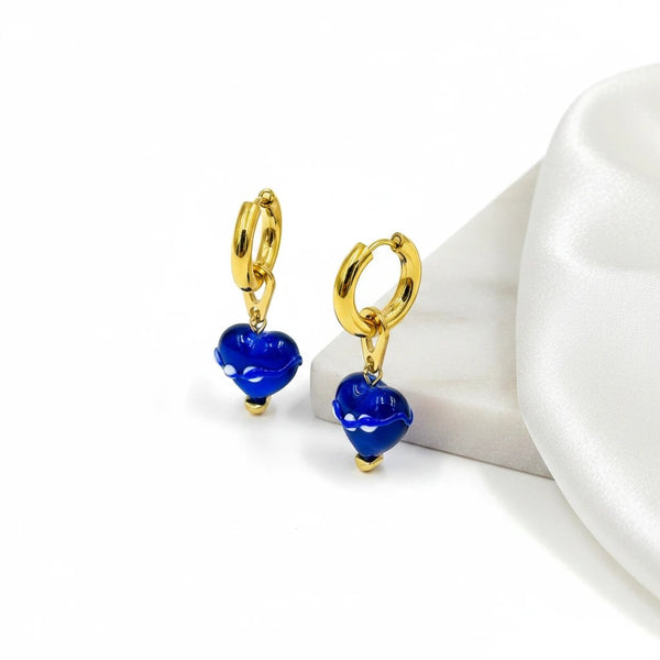 elephantina.gr gold hoop earrings with dangling blue ceramic heart charms featuring white details on a white surface.
