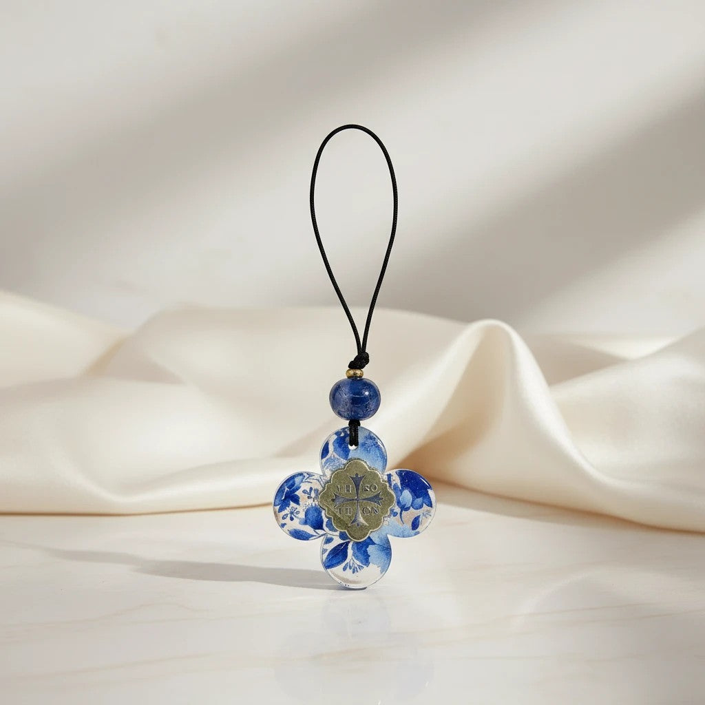 Blue floral quatrefoil charm with religious icon, suspended from a black cord with blue beads. elephantina.gr