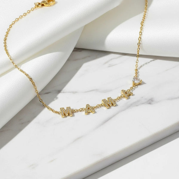 Gold plated necklace with "MAMA" spelled out in crystal-encrusted letters and a teardrop crystal charm. elephantina.gr