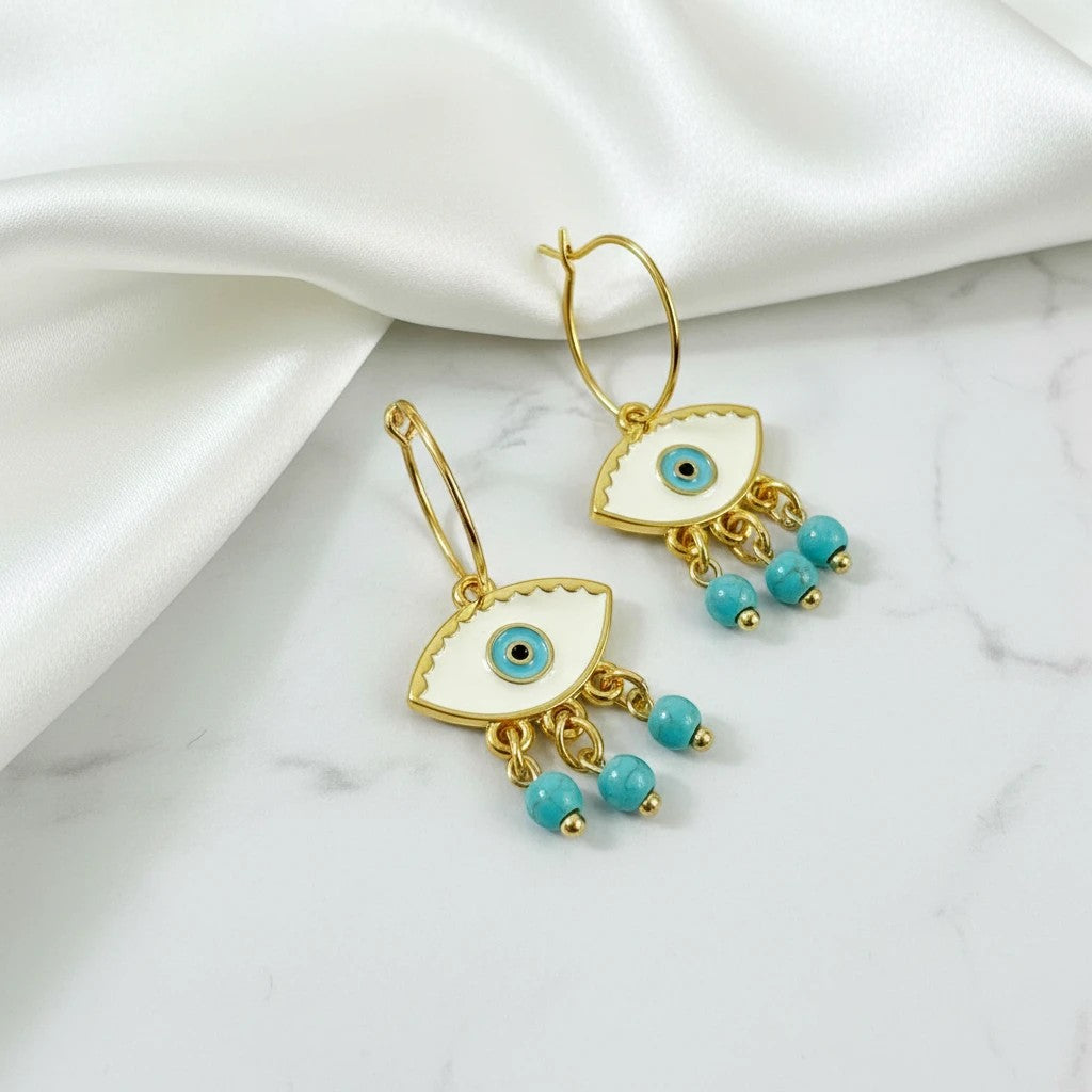 Elephantina.gr gold hoop earrings with white enamel evil eye charms and turquoise beads.