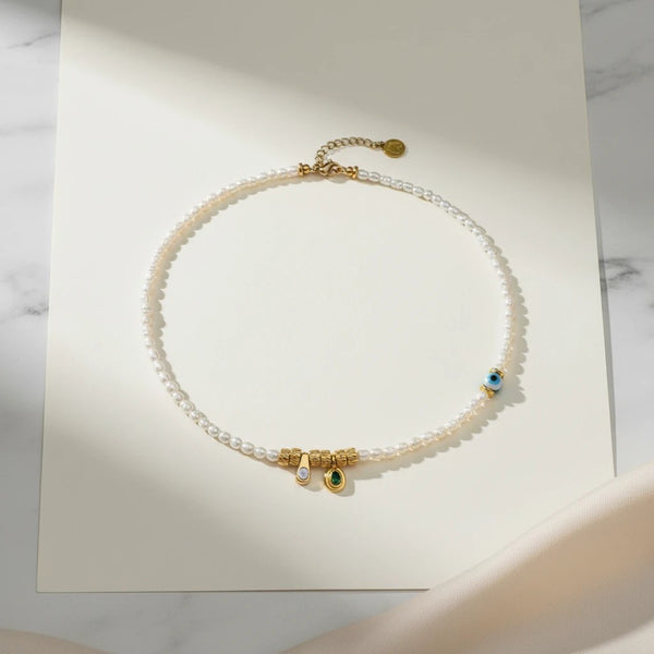 Elephantina.gr handmade necklace with small white pearls, gold elements, enamel, and evil eye charm. 40cm + 5cm extension.