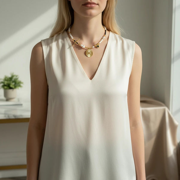 Elephantina.gr Helios Noir necklace with ivory pearls, black crystals, gold sun pendant, and baroque pearl accent.