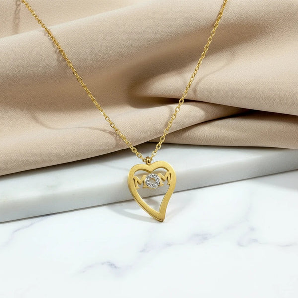 Gold tone stainless steel necklace with a heart-shaped pendant featuring the word "Mom" and a crystal accent. elephantina.gr