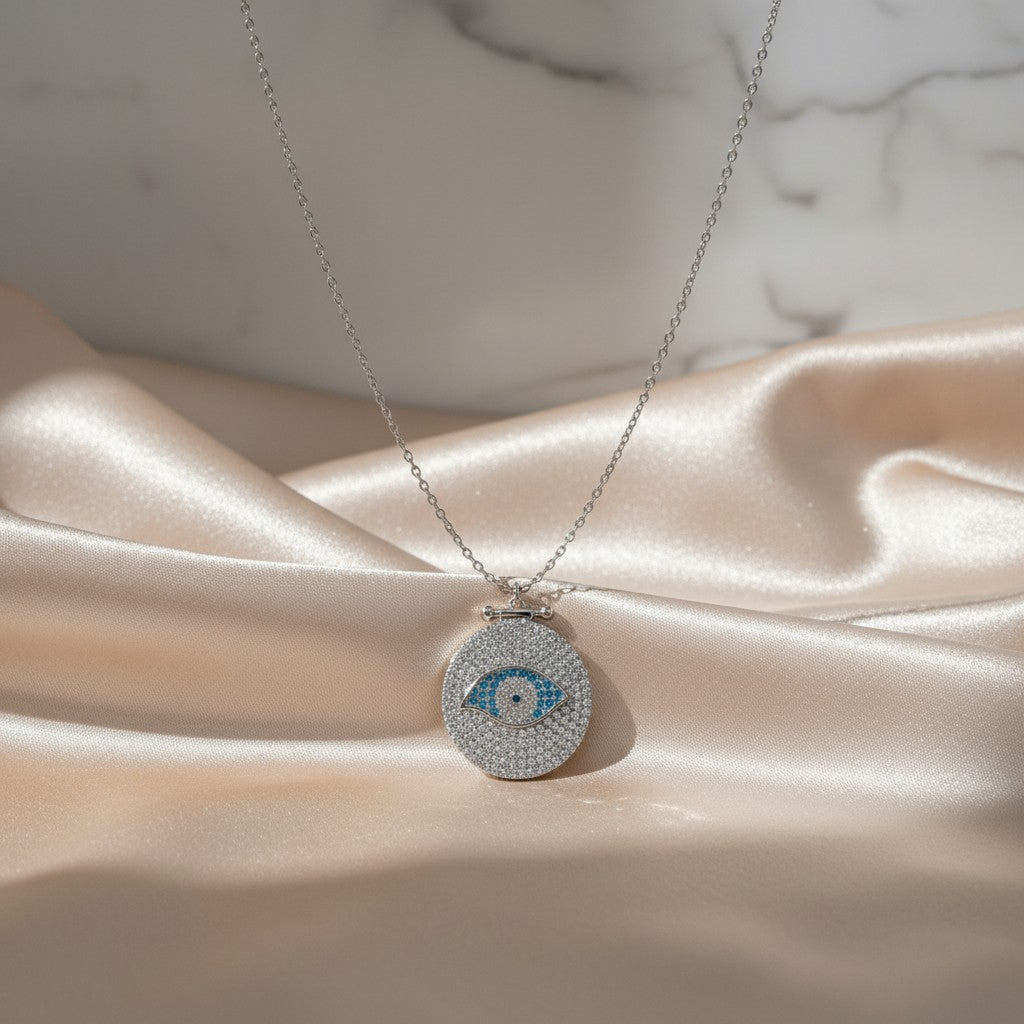 Elephantina.gr silver necklace with a round evil eye pendant encrusted with clear and blue crystals.