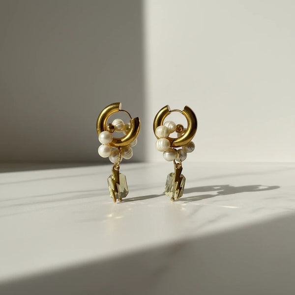 Elephantina.gr gold-tone hoop earrings with freshwater pearls and lightning bolt crystal charms.