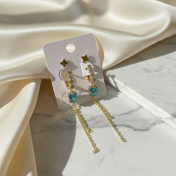 Elephantina.gr gold plated dangle earrings with aquamarine-colored square gems and cubic zirconia accents. Includes matching star studs.