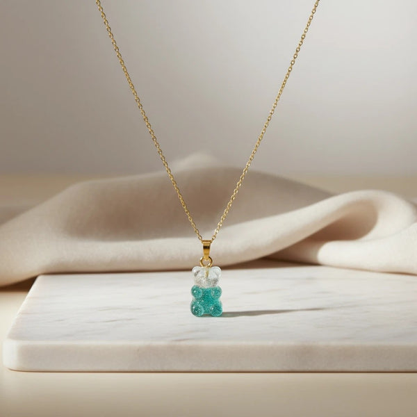 elephantina.gr gold chain necklace with a clear and turquoise glitter gummy bear pendant.
