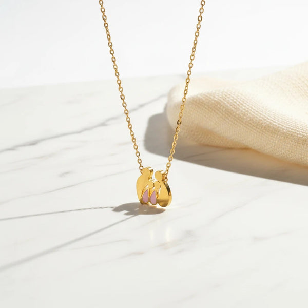 elephantina.gr gold-tone steel family necklace featuring mom, dad, and two daughters with pink enamel accents.