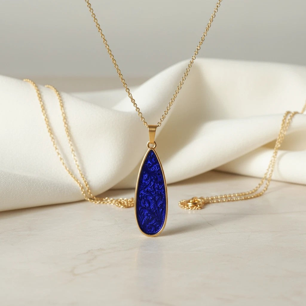 Elephantina.gr gold teardrop pendant necklace with iridescent purple-blue enamel inlay and 24K gold-plated chain.