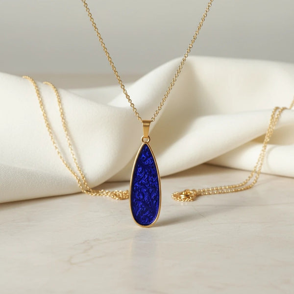 Elephantina.gr gold teardrop pendant necklace with iridescent purple-blue enamel inlay and 24K gold-plated chain.
