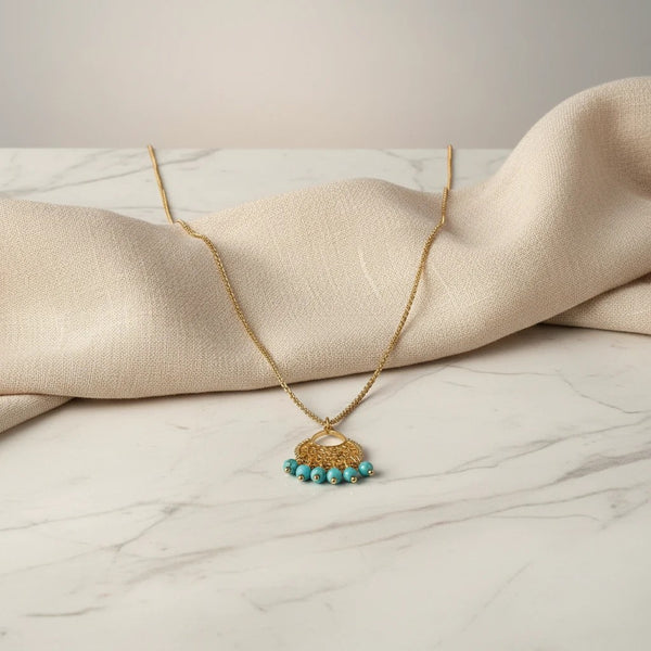elephantina.gr long boho necklace with 24K gold plated chain, intricate metalwork, and turquoise beads.