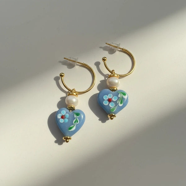 elephantina.gr gold hoop earrings with blue heart-shaped ceramic stones, hand-painted with flowers and pearls.