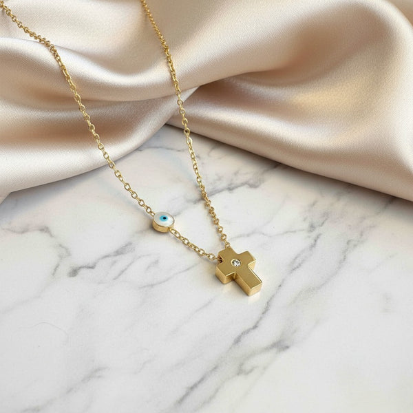 elephantina.gr gold-plated steel cross necklace with a white mother-of-pearl evil eye charm on a delicate chain.