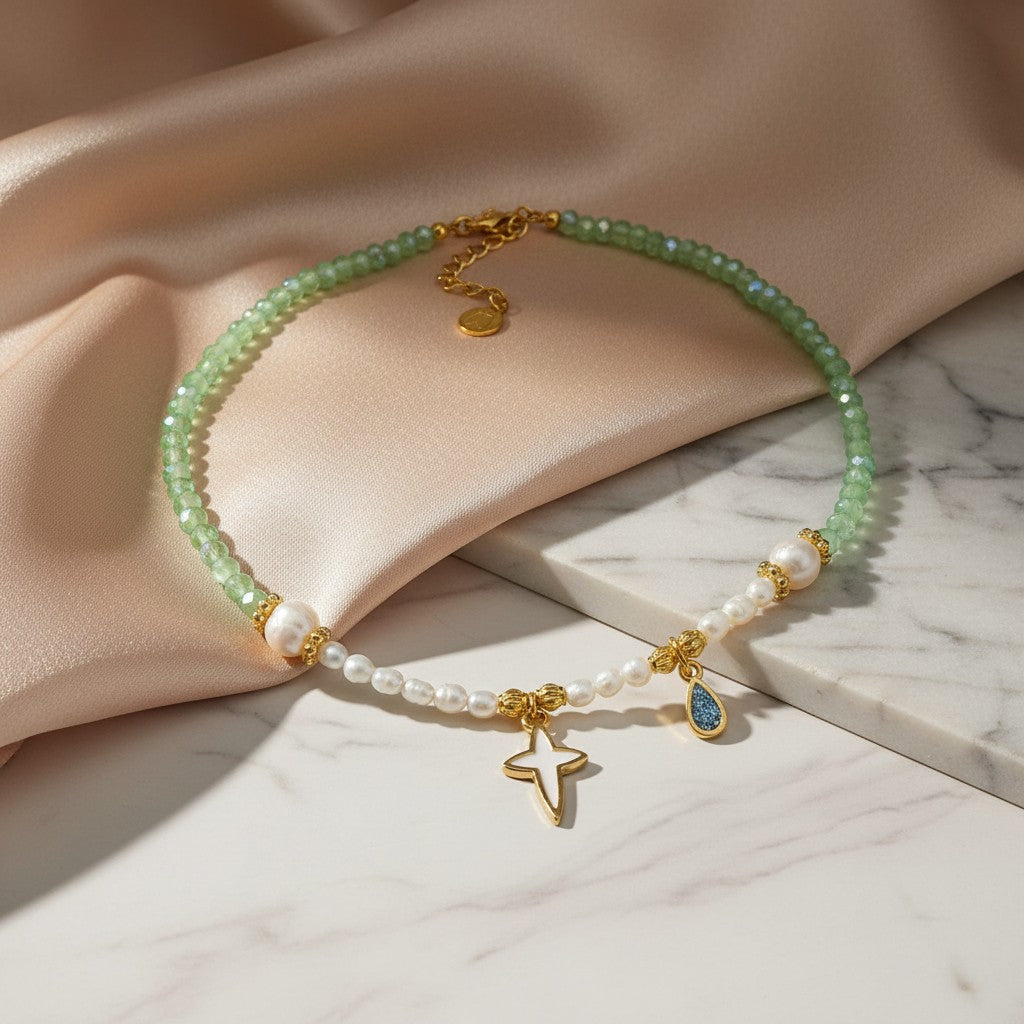 elephantina.gr necklace with pearls, green beads, gold details, and a white enamel cross charm.