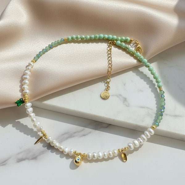 elephantina.gr handmade necklace with pearls, green beads, gold eye charm, and emerald green stone.