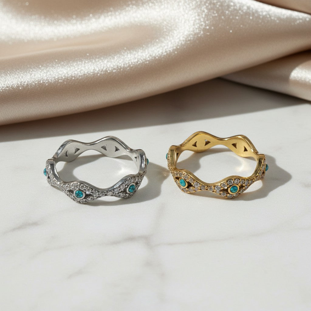 elephantina.gr silver and gold tone wave rings with pavé crystals and teal accents on a white marble surface
