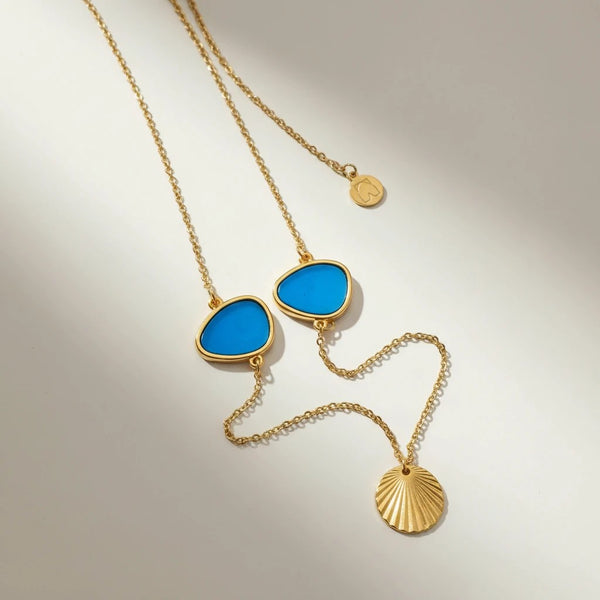 Elephantina.gr gold chain necklace with two blue enamel geometric pendants and a shell charm.